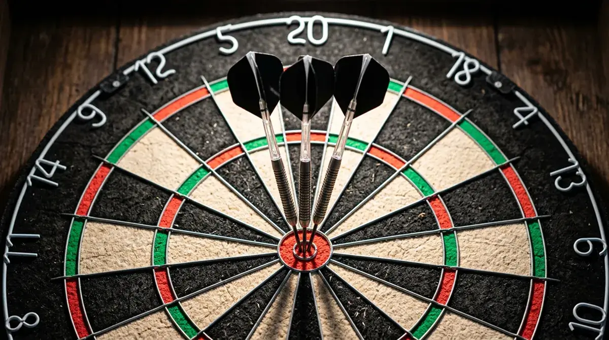 Darts Live-Übertragung: scharf fokussierte Sisal-Dartscheibe mit drei Steeldarts im Bullseye unter Hallenscheinwerfern